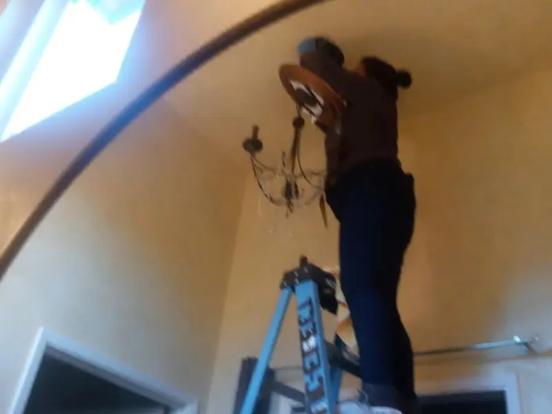 Electrician installing a chandelier in a Buchanan residence